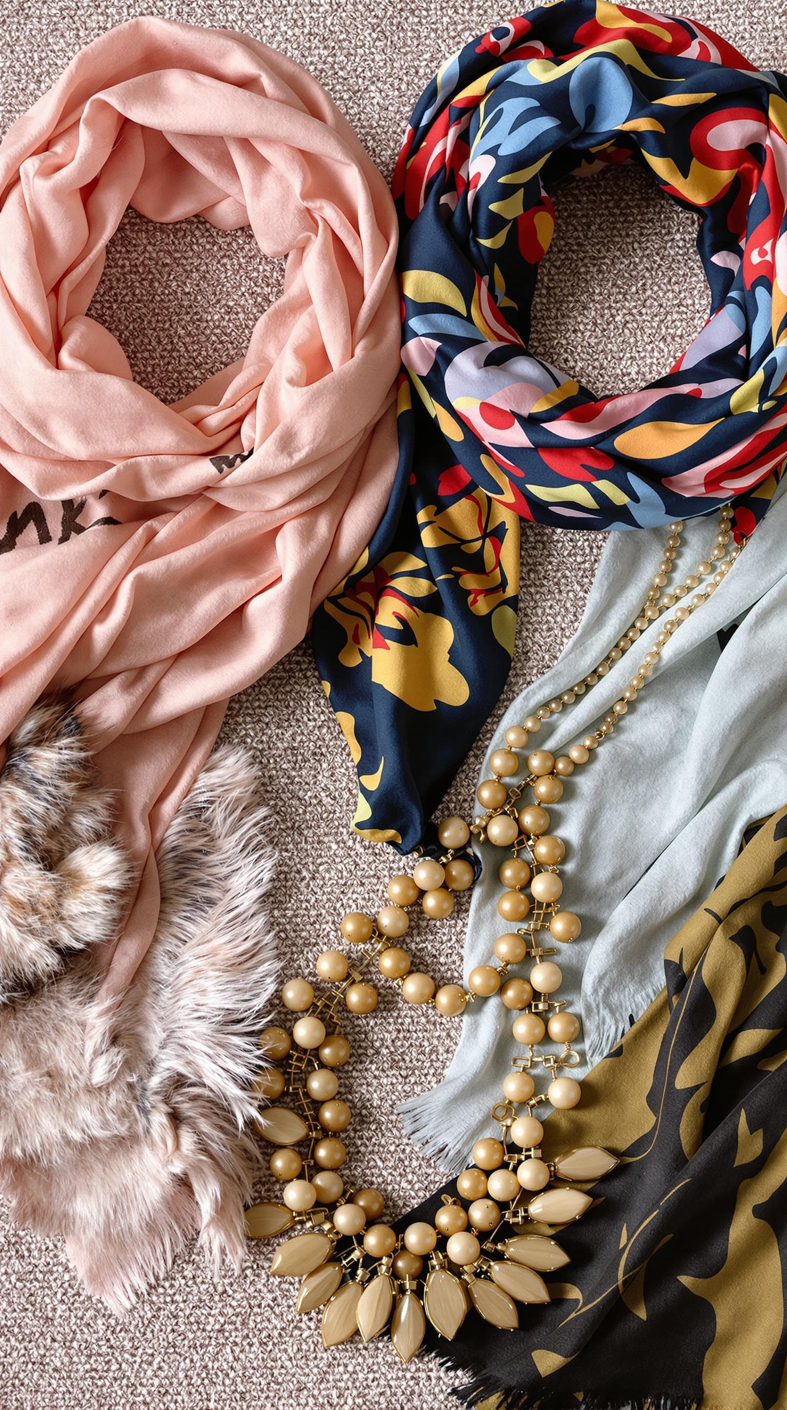 A collection of scarves and a necklace showcasing vibrant colors and textures.